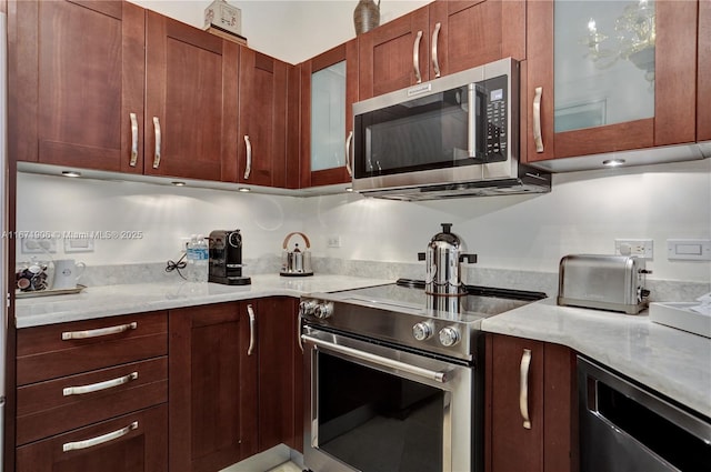 kitchen featuring stainless steel appliances and light stone countertops