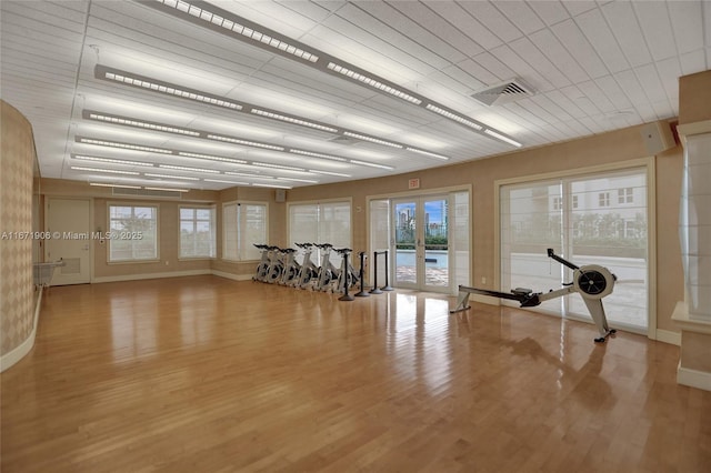 exercise area featuring wood-type flooring and french doors