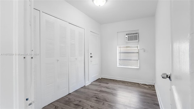 unfurnished bedroom with light wood-type flooring and a wall mounted air conditioner