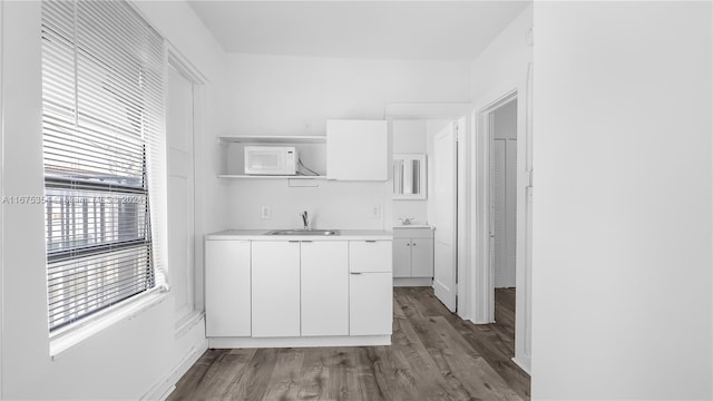 kitchen featuring dark hardwood / wood-style floors, sink, and white cabinetry