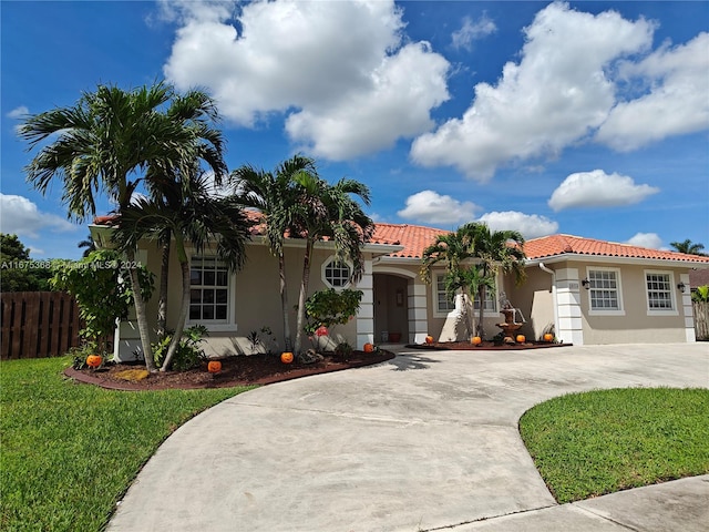 mediterranean / spanish-style house with a garage and a front lawn