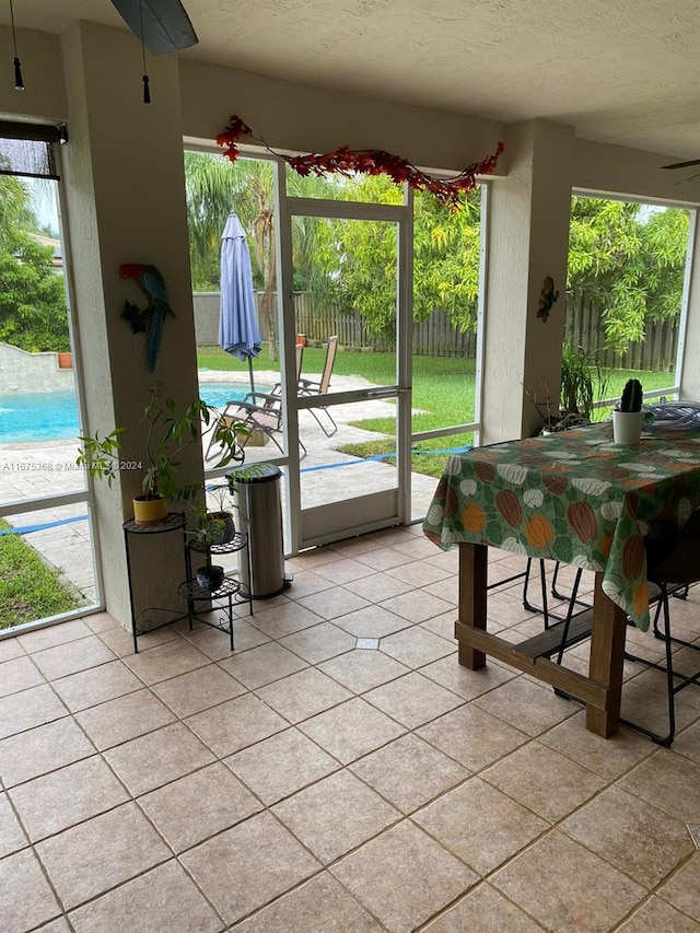 exterior space featuring light tile patterned flooring, a wealth of natural light, and ceiling fan