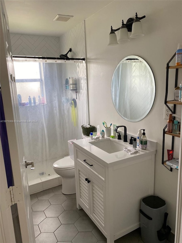 bathroom with tile patterned floors, a shower with shower curtain, vanity, and toilet