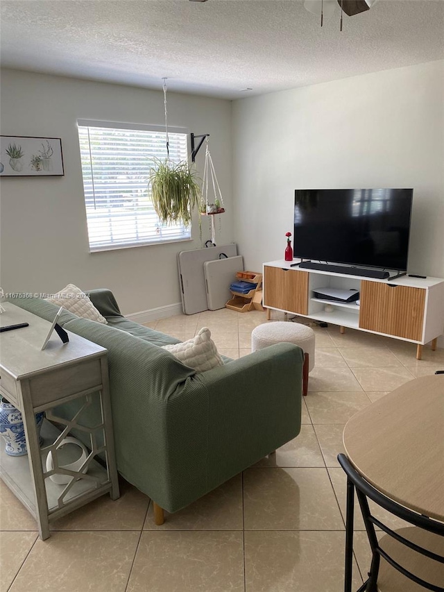 tiled living room with ceiling fan and a textured ceiling