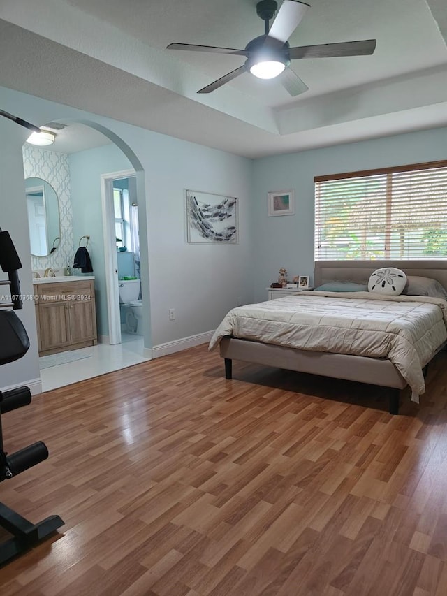 bedroom featuring ceiling fan, hardwood / wood-style flooring, and connected bathroom