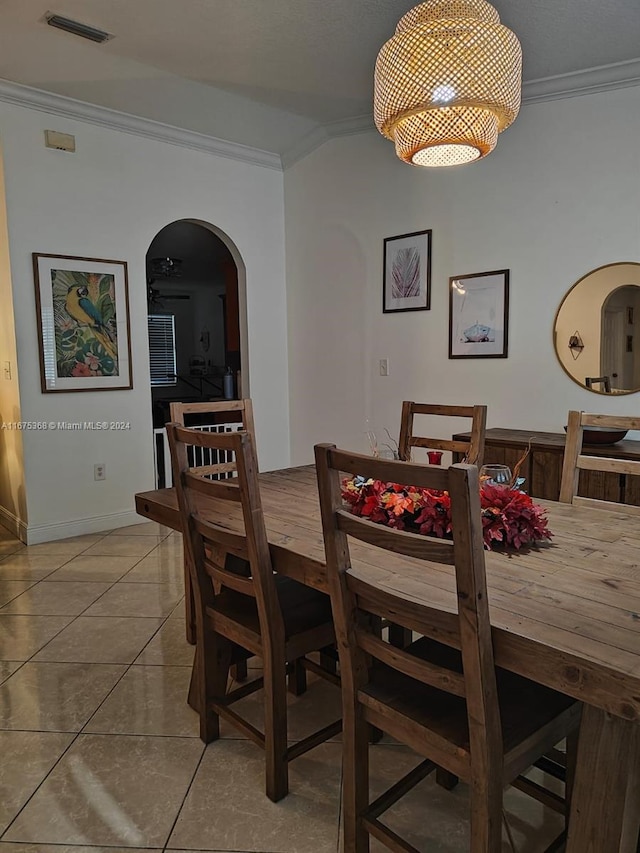 dining space featuring light tile patterned floors and ornamental molding