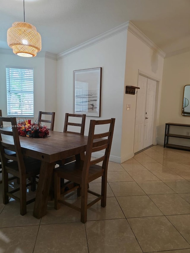 tiled dining space featuring crown molding