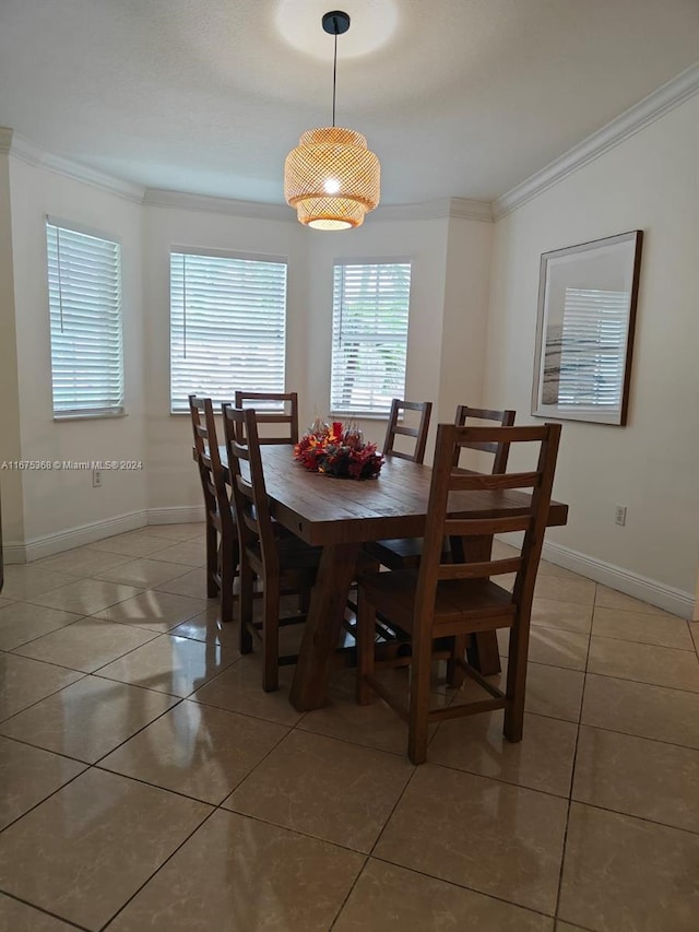 tiled dining room featuring ornamental molding