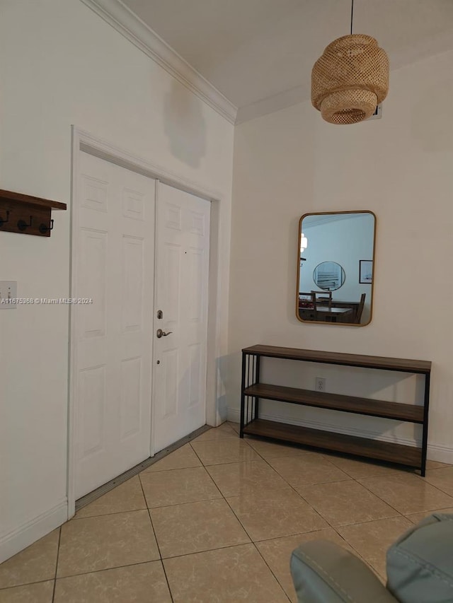 tiled entrance foyer featuring crown molding