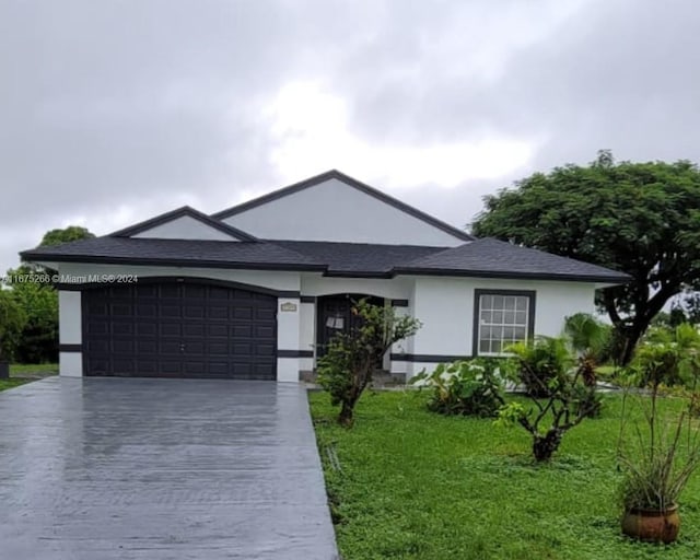 ranch-style house featuring a garage and a front lawn