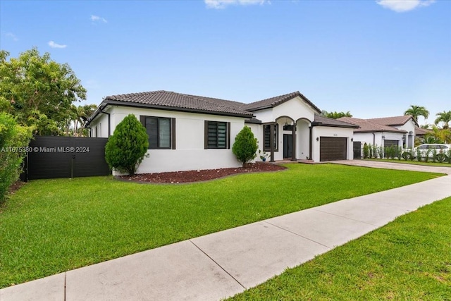 view of front of property with a garage and a front lawn