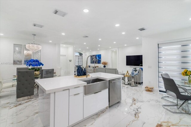 kitchen featuring sink, a center island with sink, decorative light fixtures, white cabinetry, and dishwasher