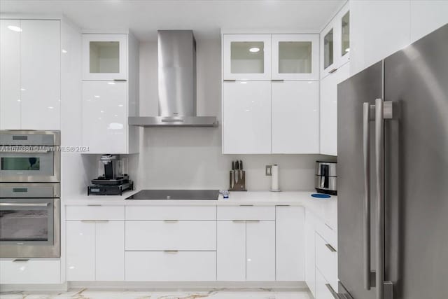 kitchen featuring stainless steel appliances, wall chimney exhaust hood, and white cabinetry