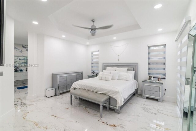 bedroom featuring ceiling fan and a tray ceiling