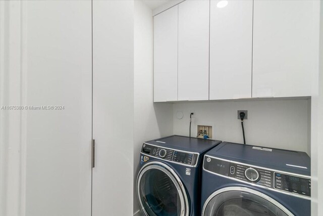 laundry room featuring washing machine and dryer and cabinets