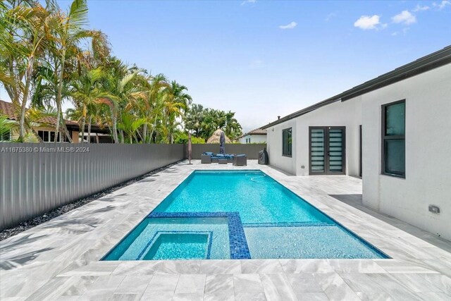 view of pool with an in ground hot tub and a patio