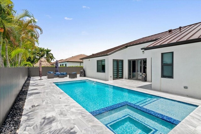 view of swimming pool with outdoor lounge area, an in ground hot tub, and a patio area