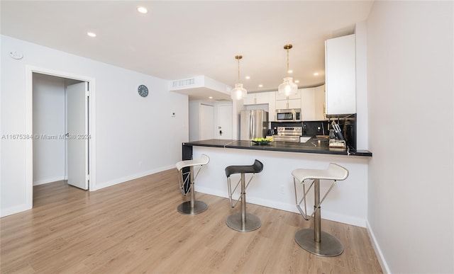600 Three Islands Blvd Unit 214, Hallandale Beach, FL 33009 - kitchen with appliances with stainless steel finishes, dark countertops, white cabinetry, a peninsula, and a kitchen breakfast bar