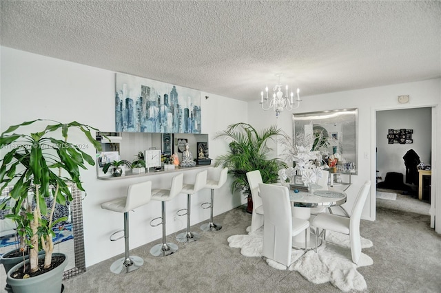 carpeted dining room featuring a chandelier and a textured ceiling