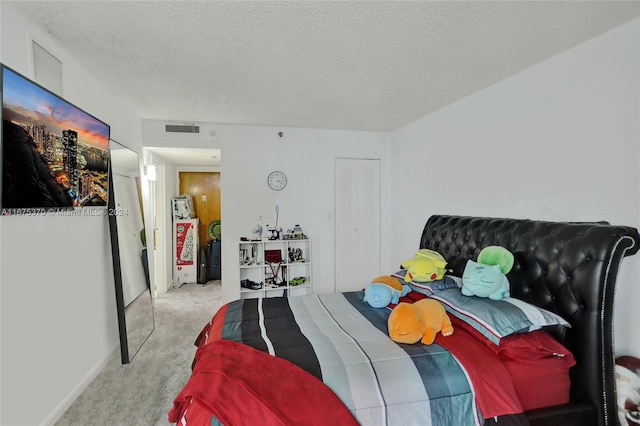 bedroom with light carpet and a textured ceiling