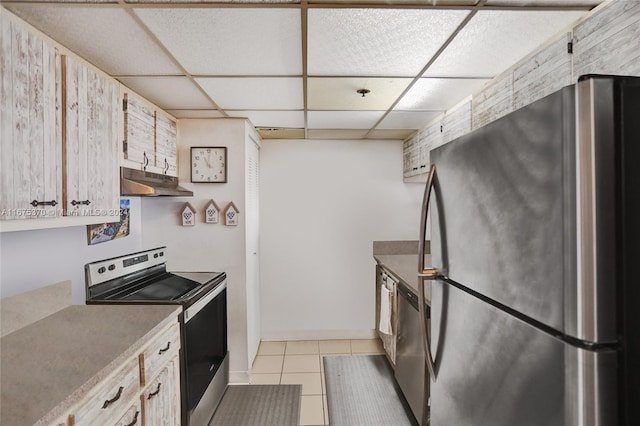 kitchen with a paneled ceiling, appliances with stainless steel finishes, and light tile patterned floors