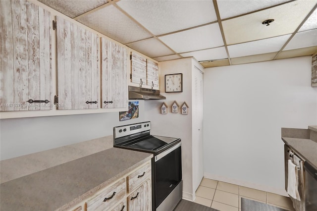 kitchen featuring electric stove, light brown cabinetry, a paneled ceiling, and tile patterned flooring