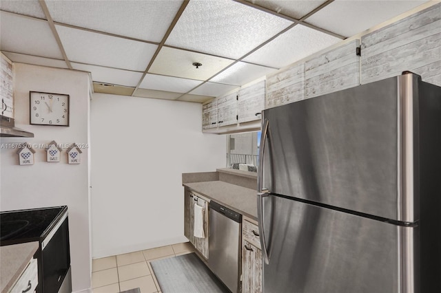 kitchen featuring appliances with stainless steel finishes, a paneled ceiling, and light tile patterned floors