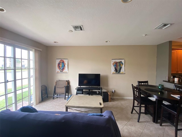 living room with a textured ceiling and light tile patterned floors