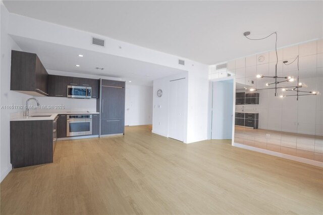 unfurnished living room with sink and light hardwood / wood-style flooring