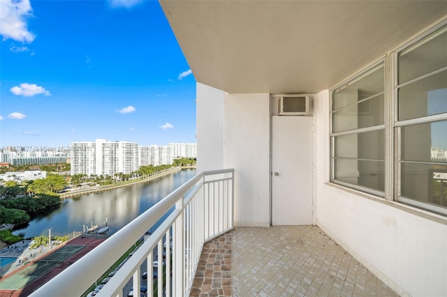 balcony with a water view and a wall mounted air conditioner