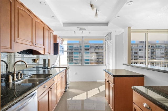 kitchen with a healthy amount of sunlight, sink, light tile patterned floors, and stainless steel appliances