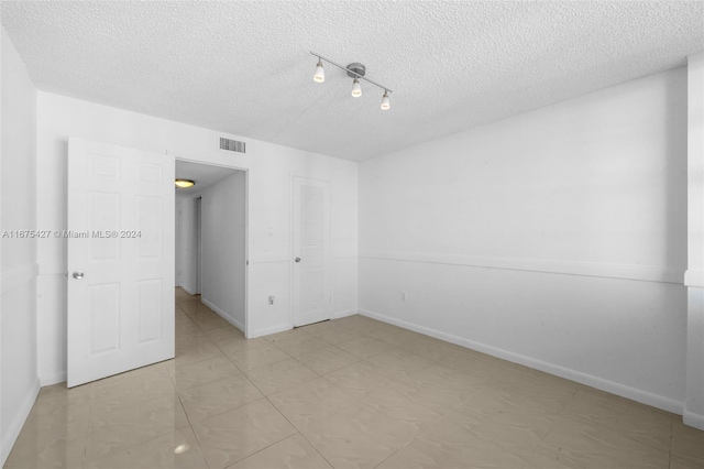 spare room with a textured ceiling