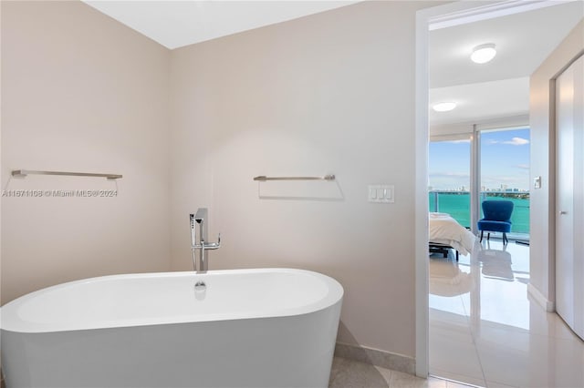 bathroom with a bathtub, a water view, and tile patterned floors