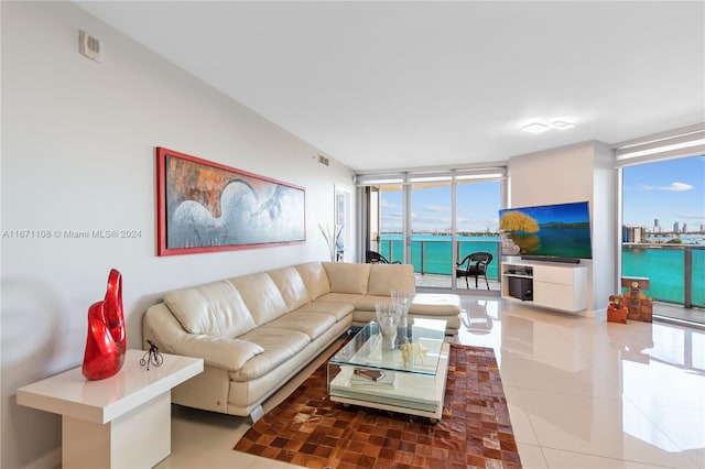 living room with a wall of windows and tile patterned flooring