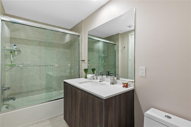 full bathroom featuring combined bath / shower with glass door, vanity, and toilet