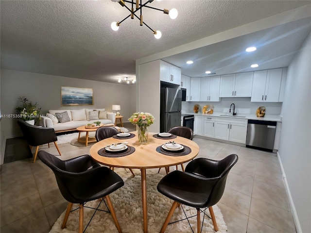 dining room featuring light tile patterned flooring, a notable chandelier, a textured ceiling, and sink