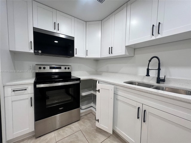 kitchen featuring light tile patterned floors, white cabinetry, light stone countertops, sink, and stainless steel appliances