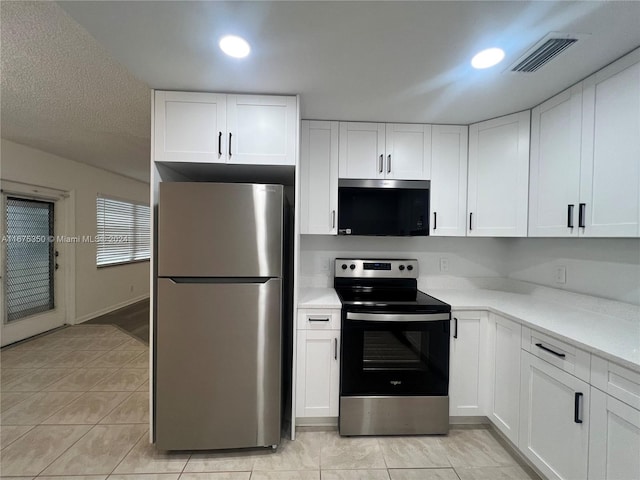 kitchen with white cabinetry, stainless steel appliances, and light tile patterned floors