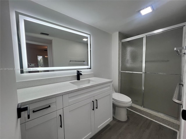 bathroom featuring vanity, an enclosed shower, toilet, and wood-type flooring