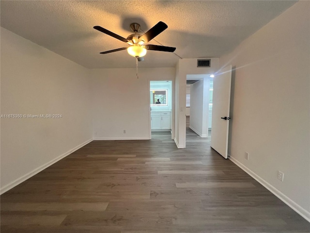 empty room featuring a textured ceiling, ceiling fan, and dark hardwood / wood-style flooring