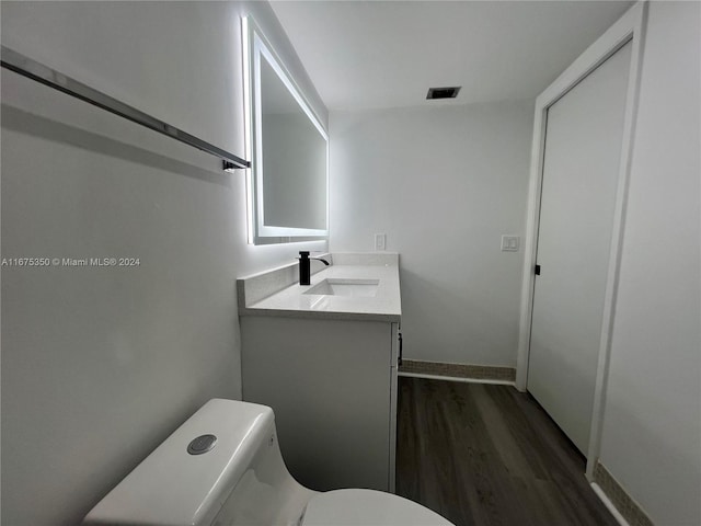 bathroom with vanity, hardwood / wood-style floors, and toilet