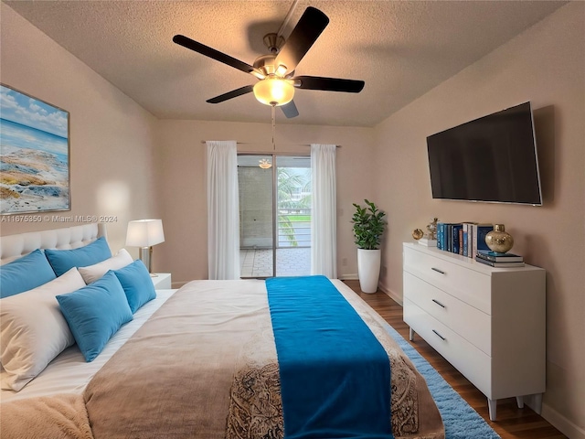 bedroom with ceiling fan, access to outside, a textured ceiling, and dark hardwood / wood-style floors