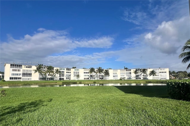 view of home's community with a water view and a lawn