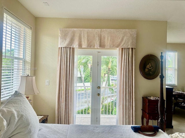 bedroom with multiple windows, access to outside, and french doors