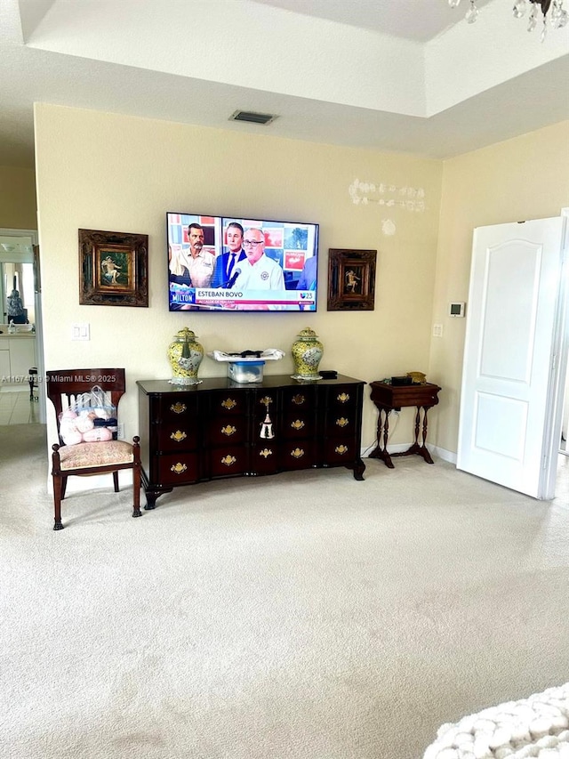 carpeted living room featuring a raised ceiling