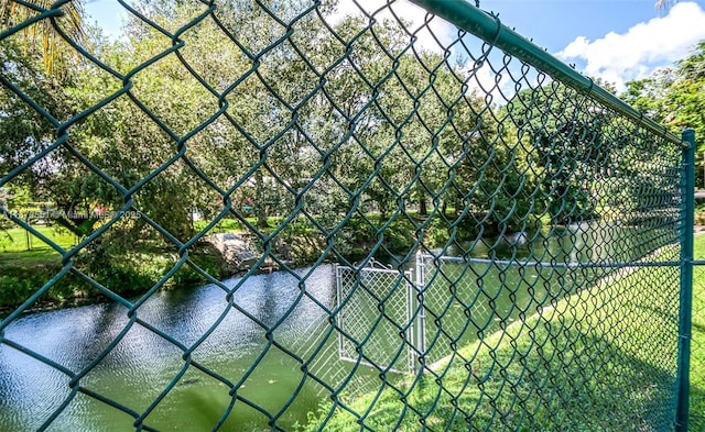 view of tennis court featuring a water view