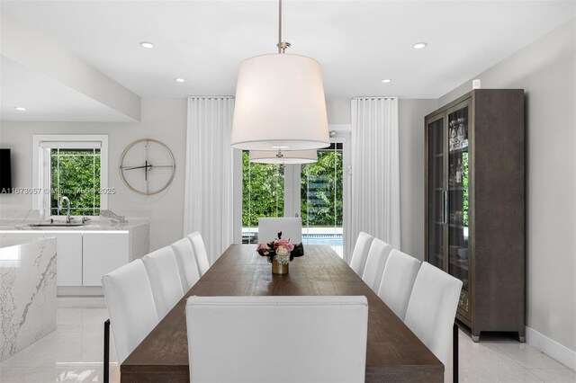 tiled dining room featuring french doors and sink