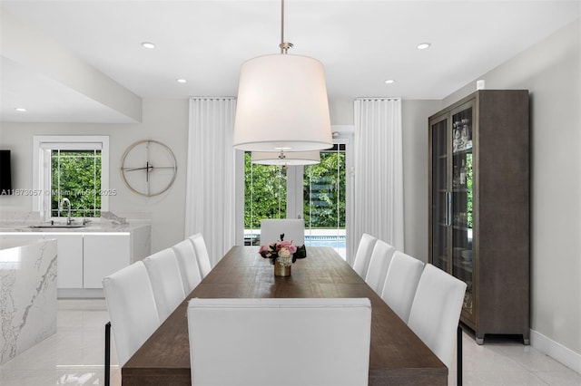 dining space with french doors, sink, and light tile patterned floors