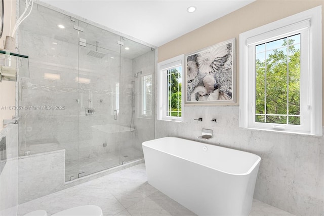 bathroom featuring plenty of natural light and shower with separate bathtub