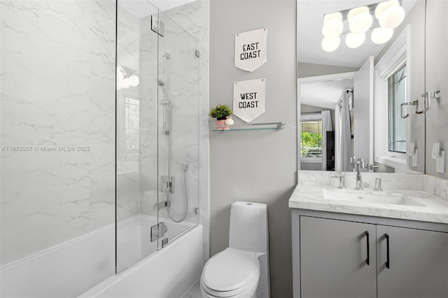 full bathroom featuring vanity, vaulted ceiling, shower / bath combination with glass door, and toilet